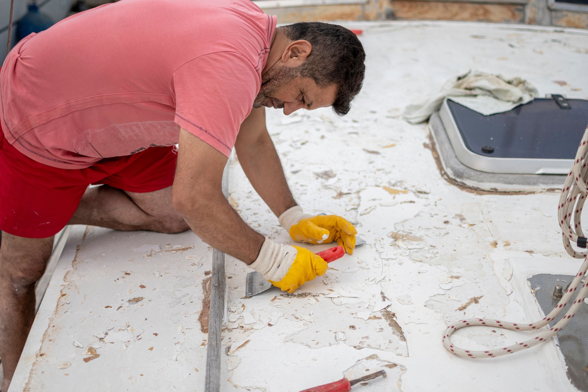 Worker repairing with spatula to boat