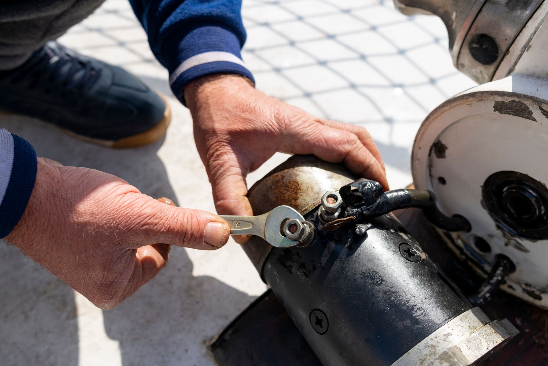 Man disassembling engine with screw wrench.