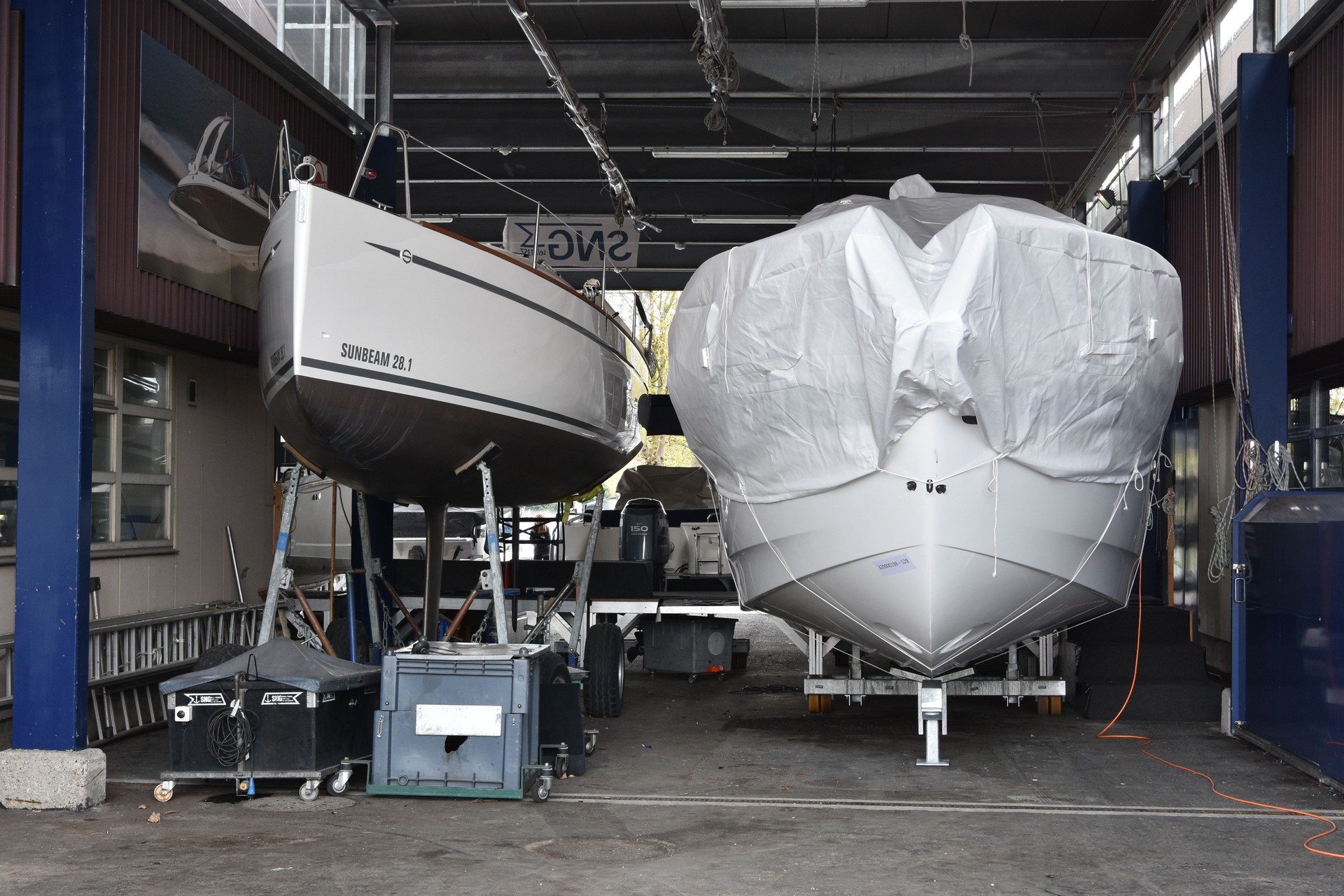 Two white yachts stored in undercover  workshops and ready for repair in marina harbor of city of Lucerne situated on Lake Lucerne